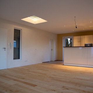 Blick in Wohn-Esszimmerm mit offener Küche des Vastu-Neubaus